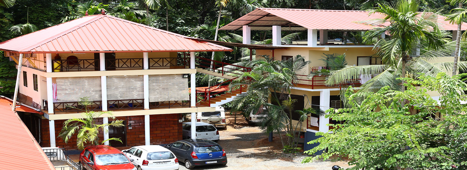 The Cherian Ashram campus buildings set among palms and greenery
