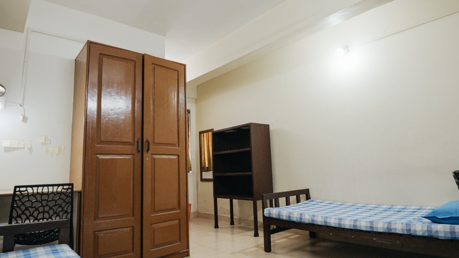 Clean furnished hostel room with beds, storage and study furniture